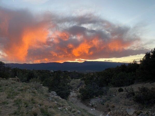 A mountainous landscape with a sunset and clouds.