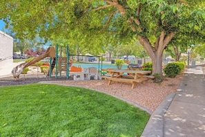 A playground with a slide, climbing structures, and a picnic table. - 2-bedroom condo in tranquil St. George with AC and fitness room (St. George)