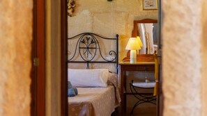 A bedroom with a bed, a bedside table with a lamp, and a chair. - Charming country house with private pool near Muro (MURO)