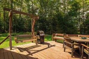 A wooden deck with a swing set, a grill, and picnic tables. - Boulder Retreat | 2BR/2BA Accident w/ Hot Tub (Accident)