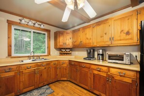 A kitchen with wooden cabinets, a double sink, a coffee maker, and a toaster. - Boulder Retreat | 2BR/2BA Accident w/ Hot Tub (Accident)