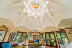A spacious room with a high ceiling, large windows, and a central seating area. - Charlestown Retreat | 2 Reflection Pools and Fire Pits (Charlestown)