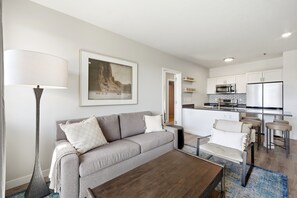 Ein modernes Wohnzimmer mit einer Couch, einem Couchtisch und einem Bild an der Wand.
