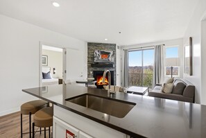 Eine moderne Küche mit Kochinsel, Kamin und Blick ins Freie.