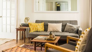Ein Wohnzimmer mit Sofa, Sessel, Couchtisch und einem Schachbrett.