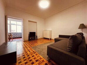 A living room with a sofa, a TV, a cabinet, and a lamp. - Spacious Porto Escape – Vale Formoso (Porto)