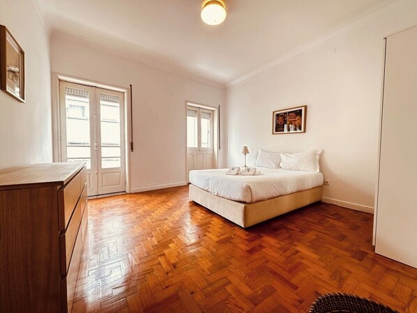 A bedroom with a bed, a dresser, and a door leading to another room. - Spacious Porto Escape – Vale Formoso (Porto)