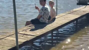 A wooden dock extending over water with a metal railing on one side.