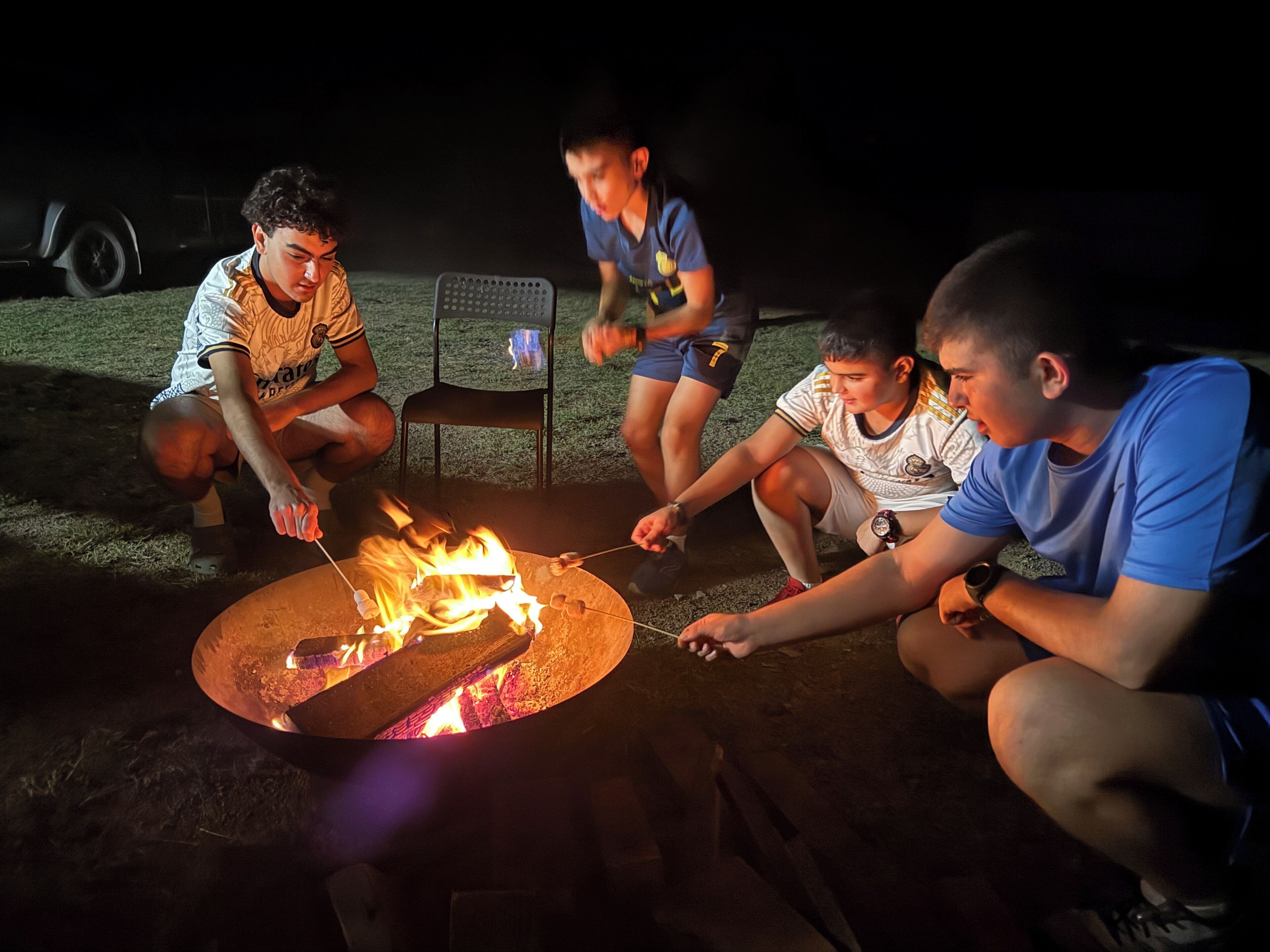 A group of people gathered around a campfire at night.
