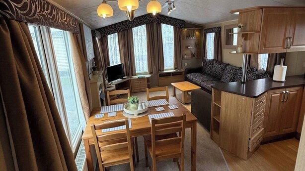 A compact living space with a dining area, kitchenette, and seating area. - 2-Bed Caravan, Sleeps 6 w/ Parking, No Pass Needed (Abergele)