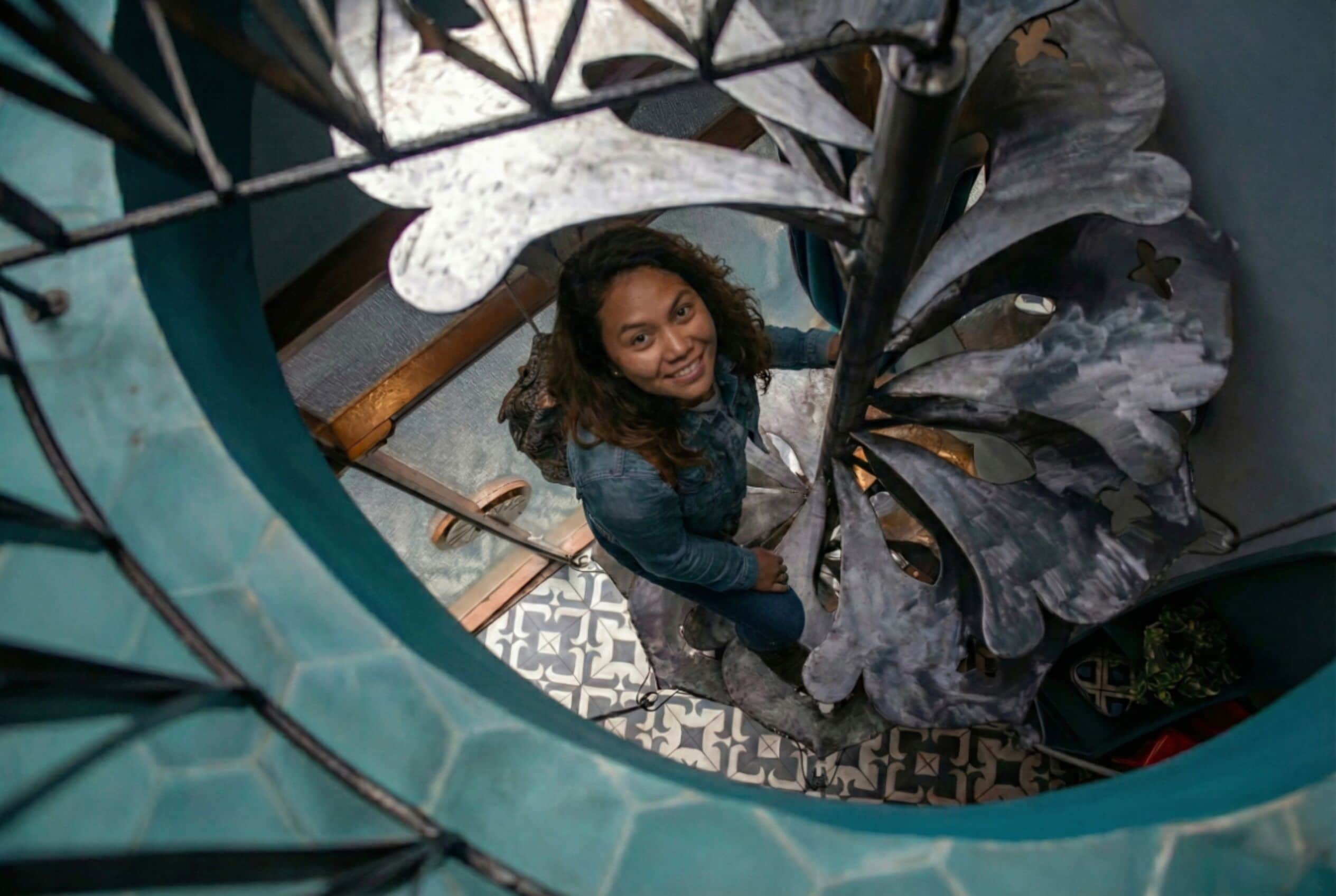 A spiral staircase with a person descending.