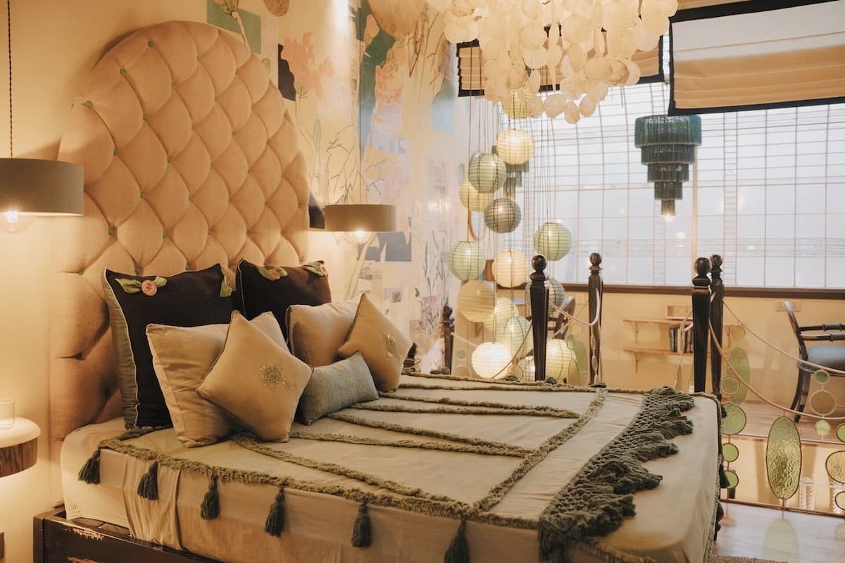 A bed with a tufted headboard, multiple pillows, and a decorative throw.