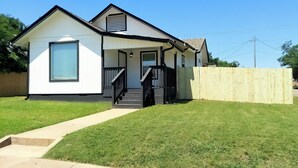 A single-story house with a front porch, a visible number '723' on the side, and a wooden fence in the background. - 3BR●Private Bath Sweets●Game Room●Casino Nearby (Durant)