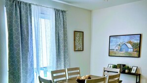 A dining area with a wooden table and chairs, a ceiling fan, and a painting on the wall. - 3BR●Private Bath Sweets●Game Room●Casino Nearby (Durant)