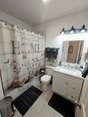 Een douche, handdoeken, zeep, shampoo