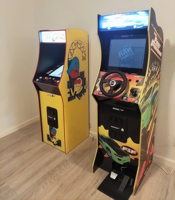 Deux bornes d’arcade aux motifs colorés et dotées d’un panneau de commande.