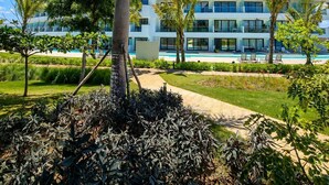 Un hôtel moderne doté d’une piscine, entouré de palmiers et de verdure.