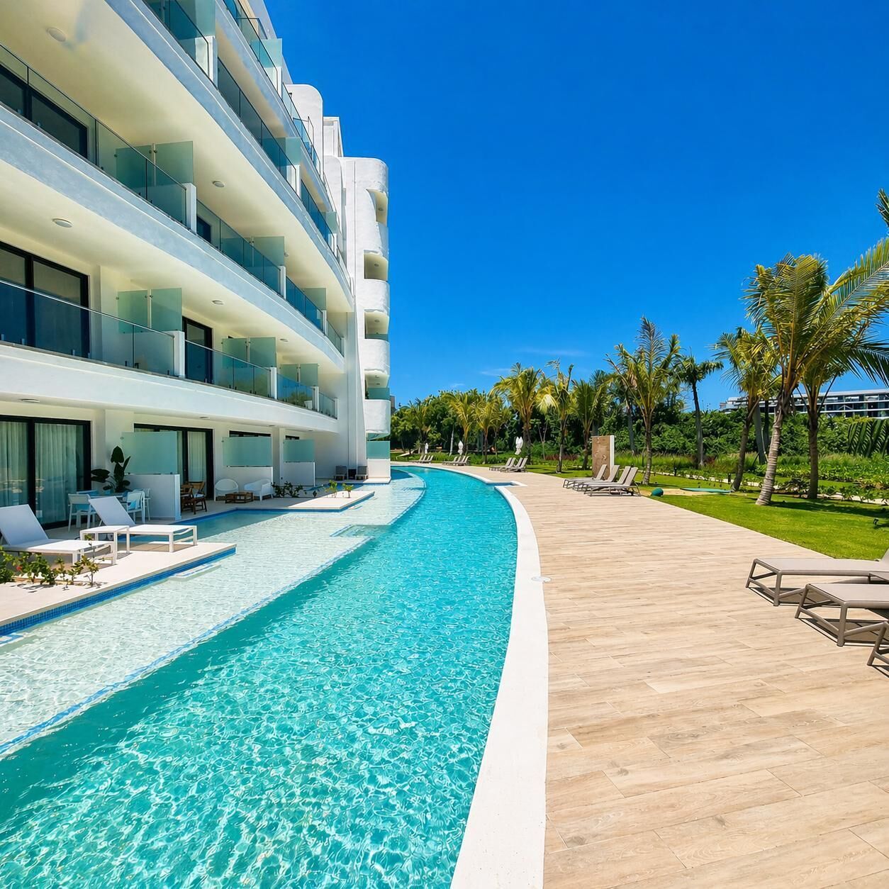 Ein modernes Hotel mit Pool, Liegestühlen und Palmen.