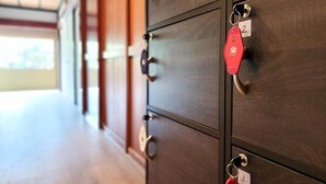 A row of wooden lockers with metal handles and numbered tags. - taipi house  (Sado)