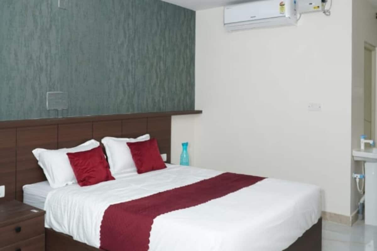 A modern bedroom with a bed, a nightstand, a ceiling fan, and an air conditioning unit.