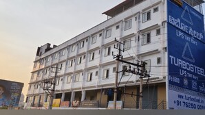 Un edificio de varios pisos con un rótulo comercial a la derecha.