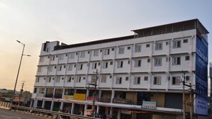 Un edificio de varios pisos con locales comerciales en la planta baja, incluyendo un banco y diversas tiendas.
