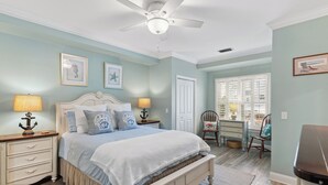 A bedroom with a bed, nightstands, a desk, and a chair. - Coastal Retreat on Beachview | Walk to Beach, Village + Family-Friendly Stay (Saint Simons Island)
