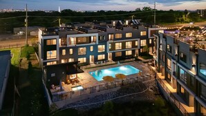 Ett hotell med flera våningar, en pool på taket, utomhusplats och utsikt över stadens silhuett.