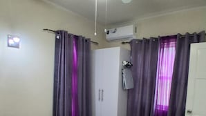 A bedroom with a bed, a ceiling fan, an air conditioning unit, and a wardrobe. - Cozy 1-bedroom apartment in fabulous Mullins, St. Peter with air conditioning! (Saint. Peter)