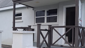 A building with a porch, a door, and a window. - Cozy 1-bedroom apartment in fabulous Mullins, St. Peter with air conditioning! (Saint. Peter)