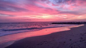 Une plage avec un ciel au coucher du soleil.