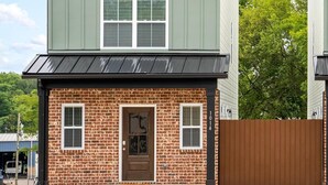 A two-story house with a brick facade, a brown door, and a green roof. - 1014 Franklin Street (Clarksville)