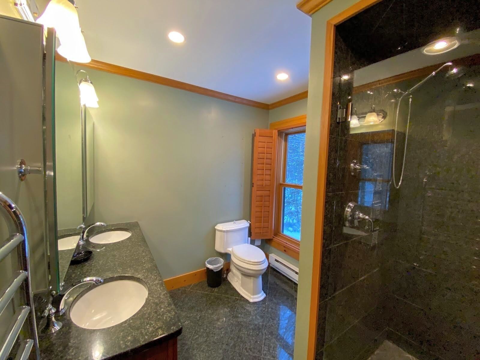 Une salle de bain avec deux lavabos, des toilettes et une douche.
