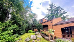 A two-story house with a wooden deck and a stone staircase leading to the entrance. - Fc42 Fabulous Mountain View Grand Resort Spa (Bretton Woods)
