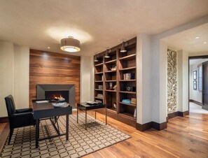 A modern living room with a fireplace, wooden shelves, and a dining area.