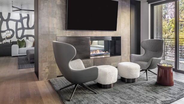 A modern living room with a fireplace, a large flat-screen TV, and contemporary furniture.