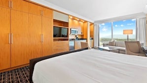 A hotel room with a large bed, a sofa, a desk, a kitchenette, and a view of the landscape. - Renovated Trump Hotel Las Vegas Studio Strip Views 2803 (Las Vegas)