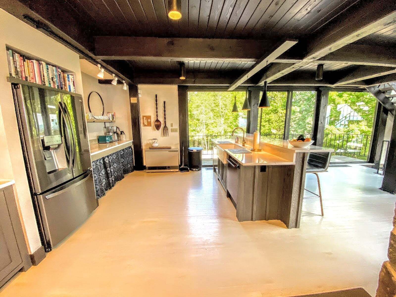 Una cocina moderna con una isla grande, electrodomésticos integrados y vistas a zonas verdes.