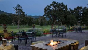 An outdoor patio area with a fire feature, seating, and a view of a golf course. - Romantic Napa Escape Prime Location King Bed, Private Patio & Pool (Napa)