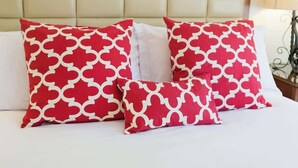 A bed with three pillows, two large and one small, all with a red and white geometric pattern. - Romantic Napa Escape Prime Location King Bed, Private Patio & Pool (Napa)