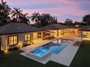 A modern house with a swimming pool, outdoor seating, and a covered patio. - Villa Banyan by Rove Travel 7BR Home W/mini Golf (North Miami Beach)