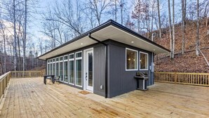 A modern cabin with a deck, large windows, and a grill area. - Primrose - Cave Run Lake OR Red River Gorge KY (Wellington)