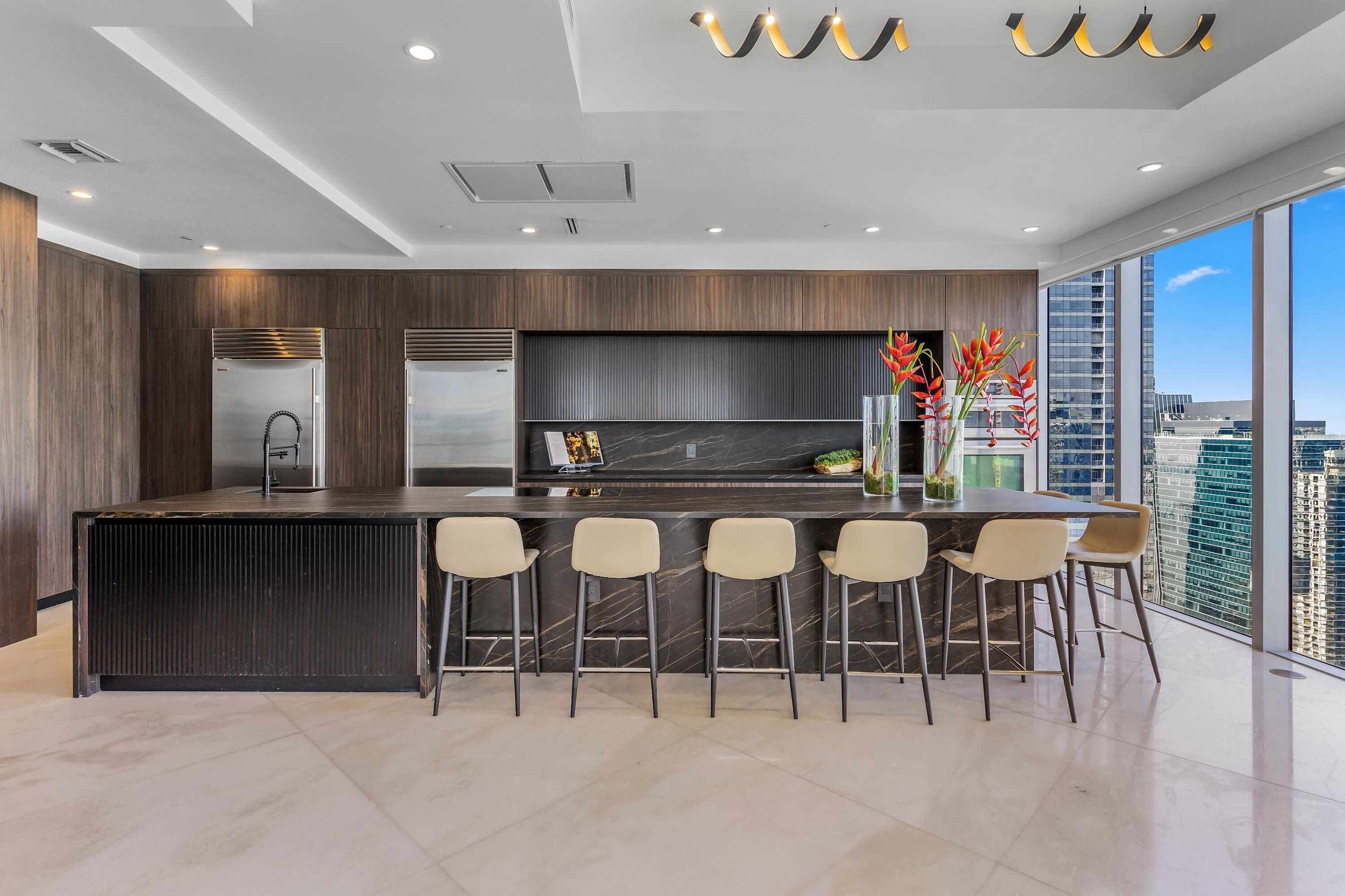 Een moderne keuken met een bar, grote ramen en uitzicht over de stad.