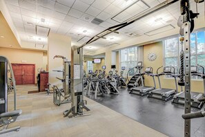 A gym with exercise equipment, a clock, and large windows. - Stunning Strip View Penthouse, Balcony 37617 (Las Vegas)