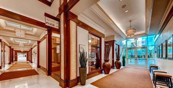 A hotel lobby with a sign for the pool, a reception desk, and a view of the outdoors. - Stunning Strip View Penthouse, Balcony 37617 (Las Vegas)