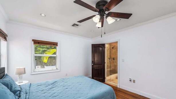 A bedroom with a bed, a ceiling fan, a window with blinds, and a door leading to a shower. - Villa Justina by Rove Villa W/pool & Hot Tub (Miami)