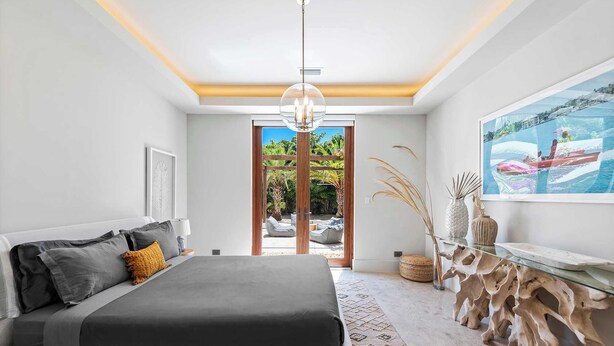 A modern bedroom with a bed, a glass coffee table, and a painting of a boat on the wall. - Villa Maroc by Rove Travel Luxury Oasis w/ Pool (Miami)