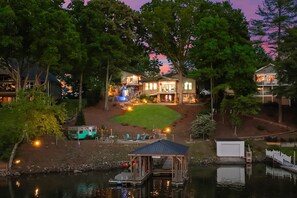 A lakeside property with a main house, a dock, and a small boat. - Nancy Key (Sherrills Ford)