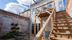 A wooden staircase leading to a balcony with a metal railing. - Downtown Urban Retreat 6 Beds Perfect for Groups (Roanoke)