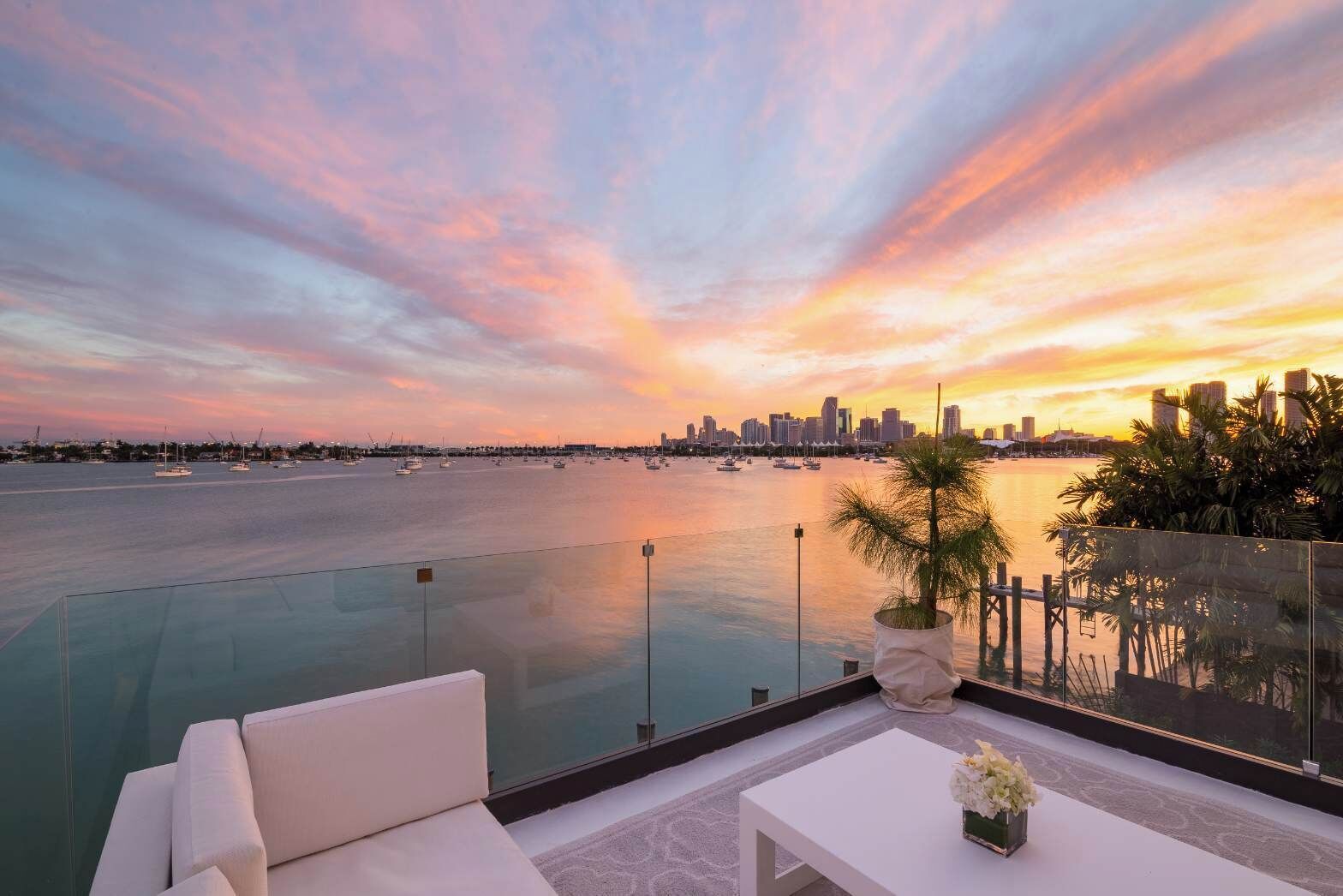 A rooftop pool with a city skyline view at sunset.